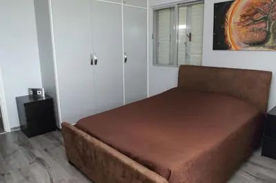 a bed in a room with a brown couch at Salt Lake view Apartment in Larnaka