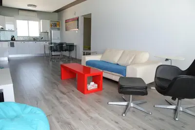 a living room with a couch and a red table at Salt Lake view Apartment in Larnaka