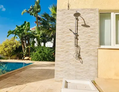 a shower on the side of a house with a pool at Panorama Luxury Villa in Protaras