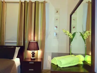 a bedroom with a mirror and a table with a lamp at Panorama Luxury Villa in Protaras
