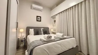 a bedroom with a bed with towels on it at SeaBreeze City Center Flats by TrulyCyprus in Limassol