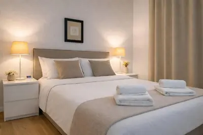 a bedroom with a large white bed with towels on it at SeaBreeze City Center Flats by TrulyCyprus in Limassol