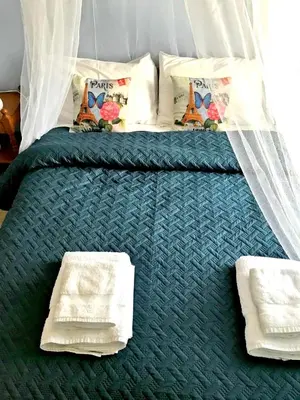 a bed with a green comforter and pillows on it at Villa Vasa in Vasa Kilaniou