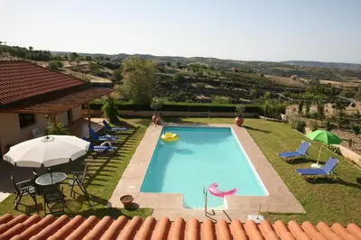 a swimming pool with an umbrella and some chairs and an umbrella at Villa Vasa in Vasa Kilaniou