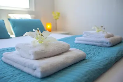 a group of towels on a bed with a candle at Protaras Villa Anemoni 6 in Protaras
