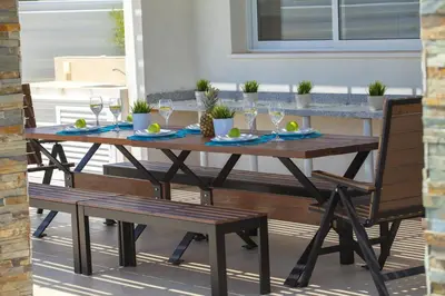 a wooden table and chairs on a patio at Protaras Villa Anemoni 6 in Protaras