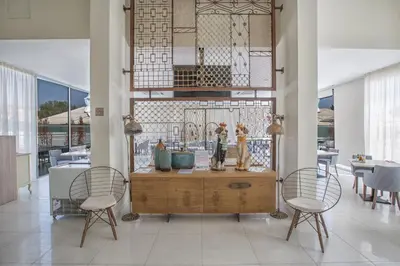a room with two chairs and a table with vases on it at NissiLant hotel & suites in Ayia Napa