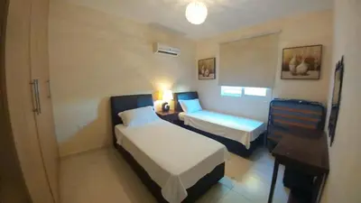 a hotel room with two beds and a table and a desk at Pyla Gardens D5 in Pyla