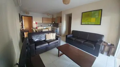 a living room with a couch and a table at Pyla Gardens D5 in Pyla