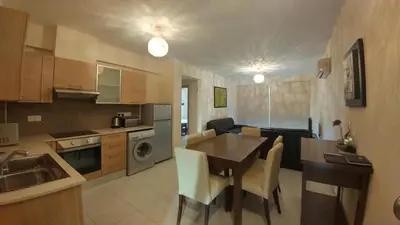a kitchen and living room with a table and a dining room at Pyla Gardens D5 in Pyla