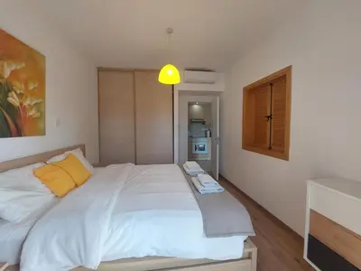 a bedroom with a large white bed with yellow pillows at Palm Beach Apartment 26 in Limassol