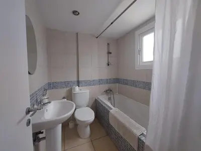 a bathroom with a toilet and a sink and a tub at Palm Beach Apartment 26 in Limassol