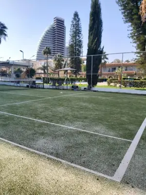 a tennis court with buildings in the background at Palm Beach Apartment 26 in Limassol