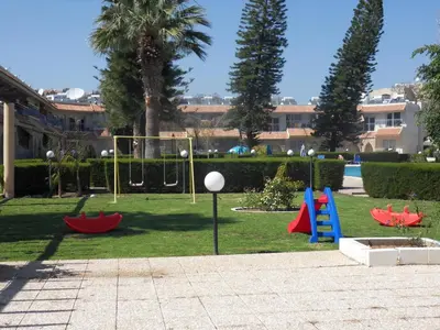 a park with a playground with a slide and a volley ball at Palm Beach Apartment 26 in Limassol