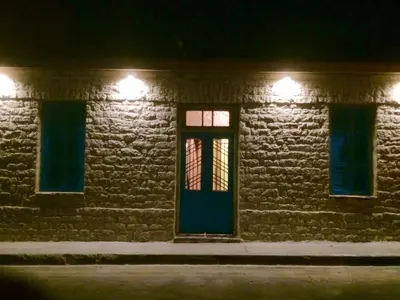 a building with a blue door and windows at night at Zouglas App Guesthouse in Limassol