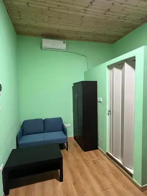 a living room with a blue couch and a cabinet at Zouglas App Guesthouse in Limassol