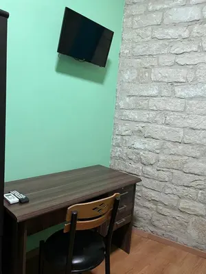 a desk with a chair and a tv on a wall at Zouglas App Guesthouse in Limassol