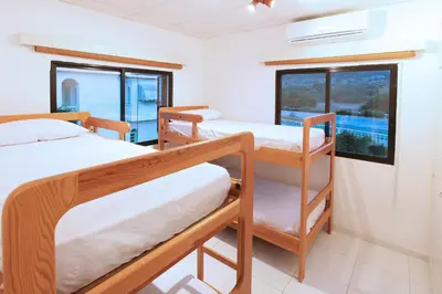 a room with three bunk beds and a window at Green Bay Villa in Protaras