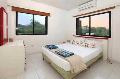 a bedroom with a bed and two windows at Green Bay Villa in Protaras