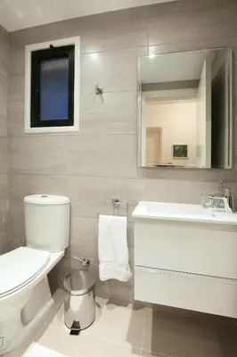 a bathroom with a toilet and a sink and a mirror at Green Bay Villa in Protaras
