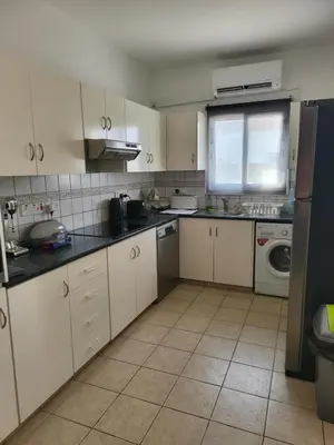 a kitchen with white cabinets and black counter tops at Villa Gracia in Ayia Napa