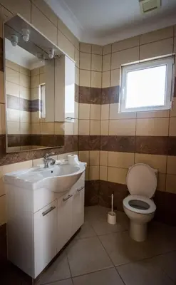 a bathroom with a toilet and a sink and a window at Panais Villa in Kiti