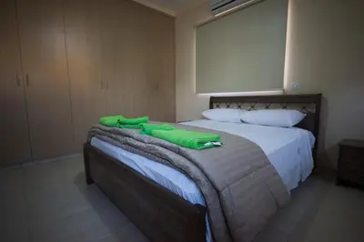 a bedroom with a bed with green towels on it at Panais Villa in Kiti