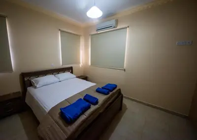 a bedroom with a bed with two blue towels on it at Panais Villa in Kiti