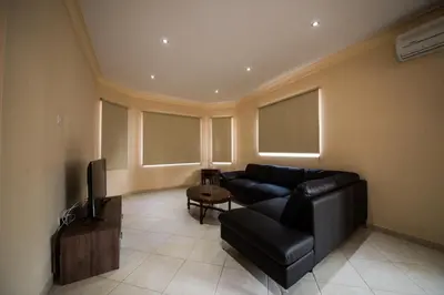 a living room with a black couch and a tv at Panais Villa in Kiti