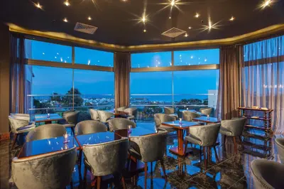 a restaurant with tables and chairs and a large window at St Raphael Resort in Limassol