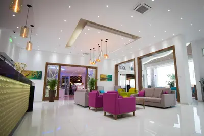 a lobby with purple and yellow chairs and tables at Loutsiana Deluxe Apts in Ayia Napa