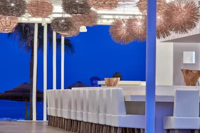 a dining room with blue walls and palm trees at So Nice Beach Resort in Ayia Napa