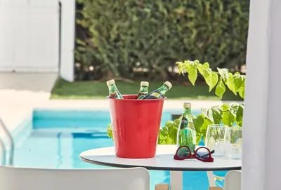 a bucket of beer bottles on a table next to a pool at So Nice Beach Resort in Ayia Napa