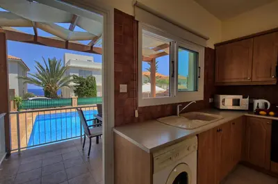 a kitchen with a view of a pool at myExclusiveVilla 683 in Protaras
