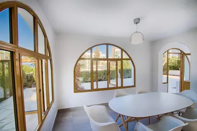a white dining room with a white table and chairs at Fig Tree Bay Villa 2 in Protaras
