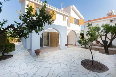 a courtyard of a house with a tree at Fig Tree Bay Villa 2 in Protaras