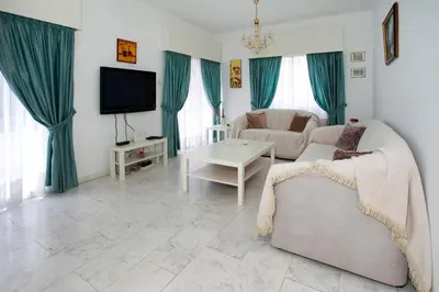 a living room with a couch and a tv at Despoina Town House in Limassol