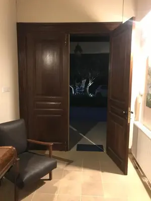 a door into a living room with a chair and a couch at Agia Mavri House in Koilani