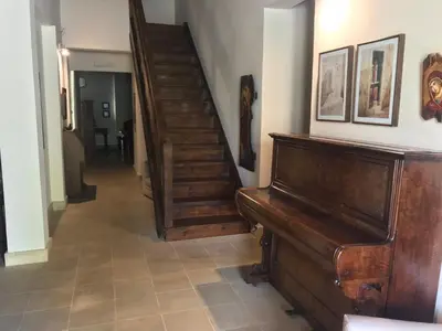 a hallway with a staircase and a wooden piano at Agia Mavri House in Koilani
