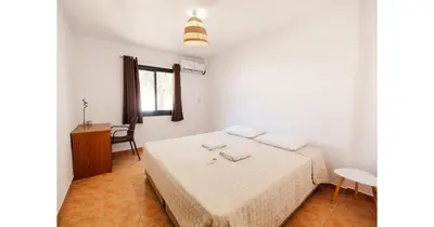 a white bedroom with a bed and a window at Urban Stays in Ayia Napa
