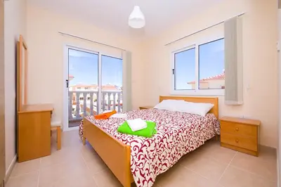 a bedroom with a bed and a large window at Villa Agnes in Ayia Napa