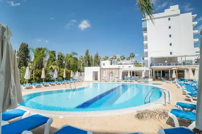 a large swimming pool with blue chairs and a building at Gaia Sun N Blue Hotel in Ayia Napa