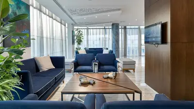 a living room with blue couches and a table at Gaia Sun N Blue Hotel in Ayia Napa