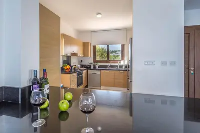 a kitchen with two glasses of wine on a table at Greko Mare Front Line in Protaras