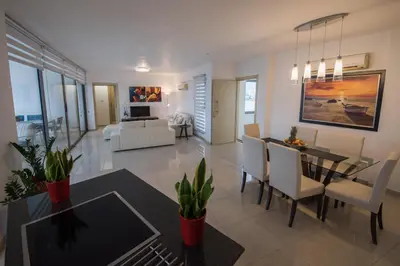 a living room and dining room with a table and chairs at Skylight Megaron in Larnaka
