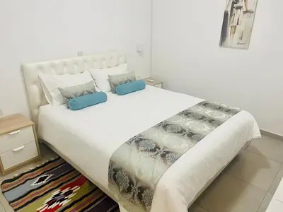 a bedroom with a large white bed with blue pillows at Riverside Suite in Kalopanayiotis