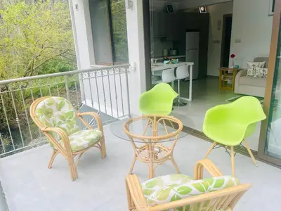 three chairs and a table on a balcony at Riverside Suite in Kalopanayiotis