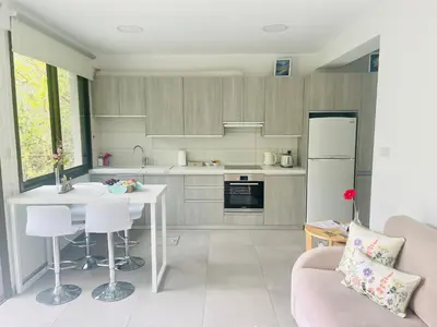 a kitchen with a couch and a table and a refrigerator at Riverside Suite in Kalopanayiotis