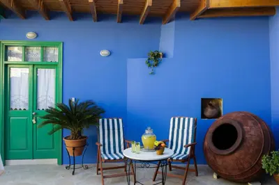 a room with a table and two chairs and a blue wall at To Konatzi tis Marikas tzai tou Yianni in Kato Drys