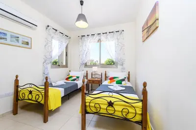 a bedroom with two beds and a window at Villa Marizan in Protaras